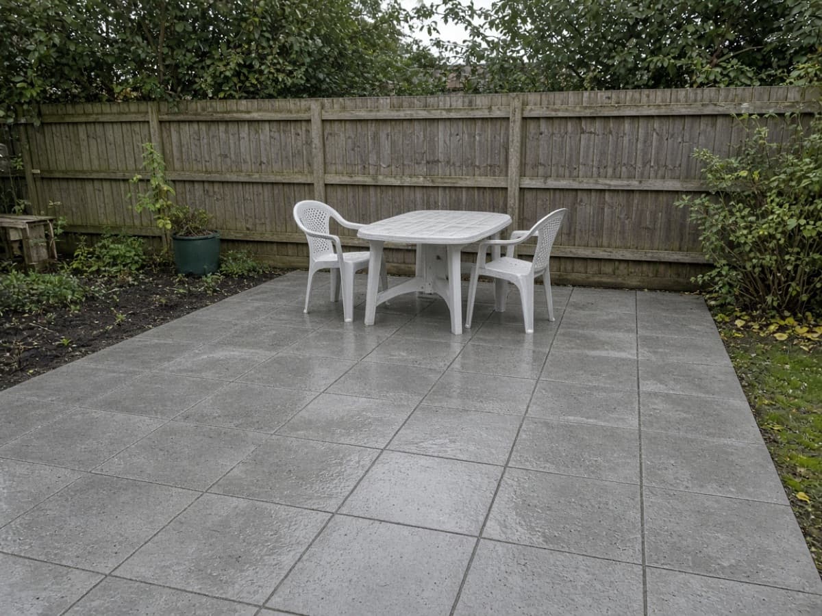 Paved patio with outdoor seating against a timber fence